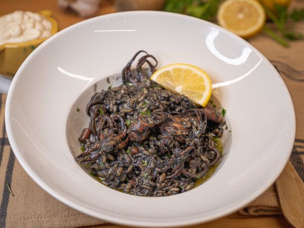 Plat preparat d'arròs negre amb popets i calamars